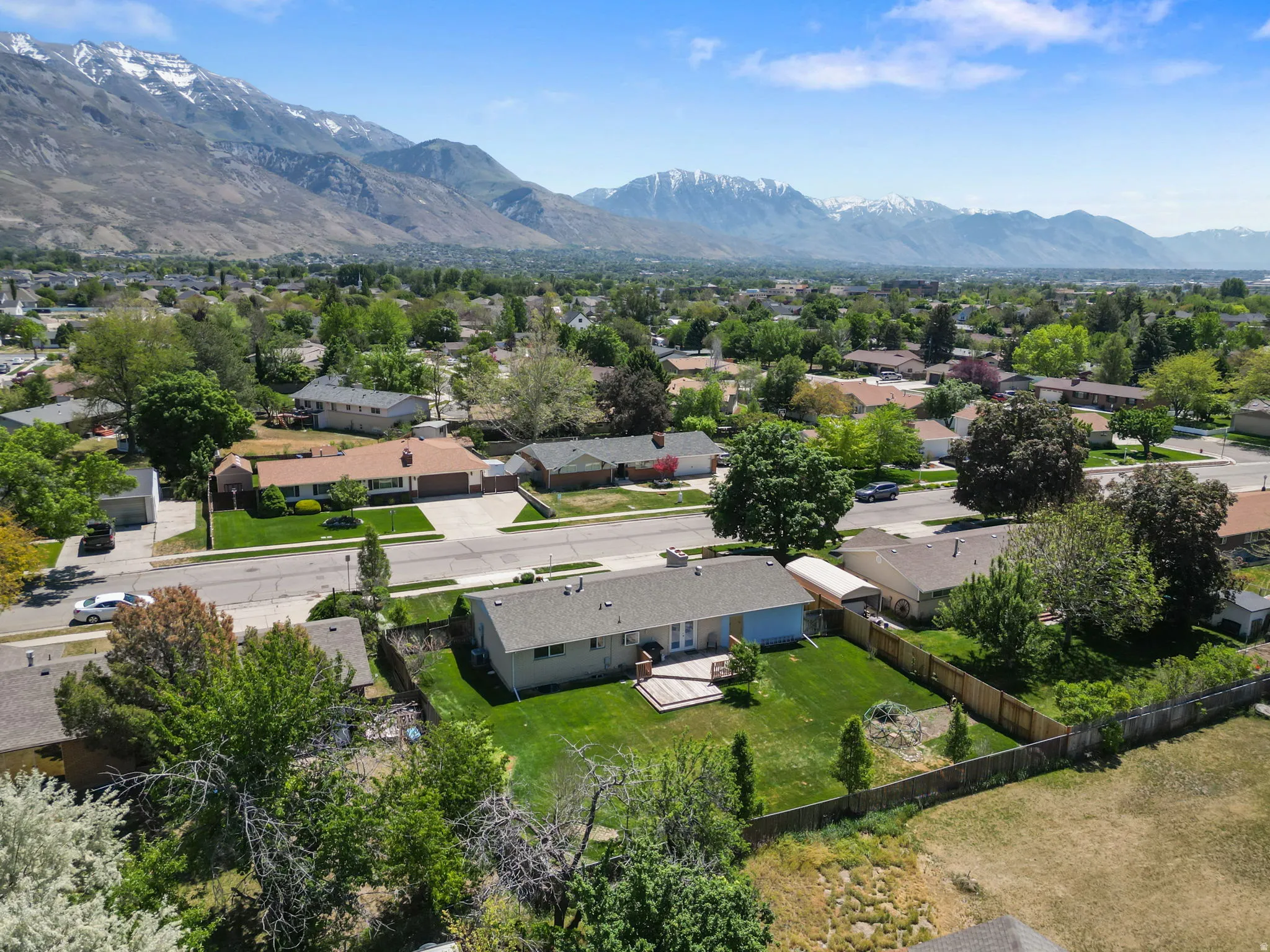 Expansive backyard with a wooden fence and a multi-level deck
