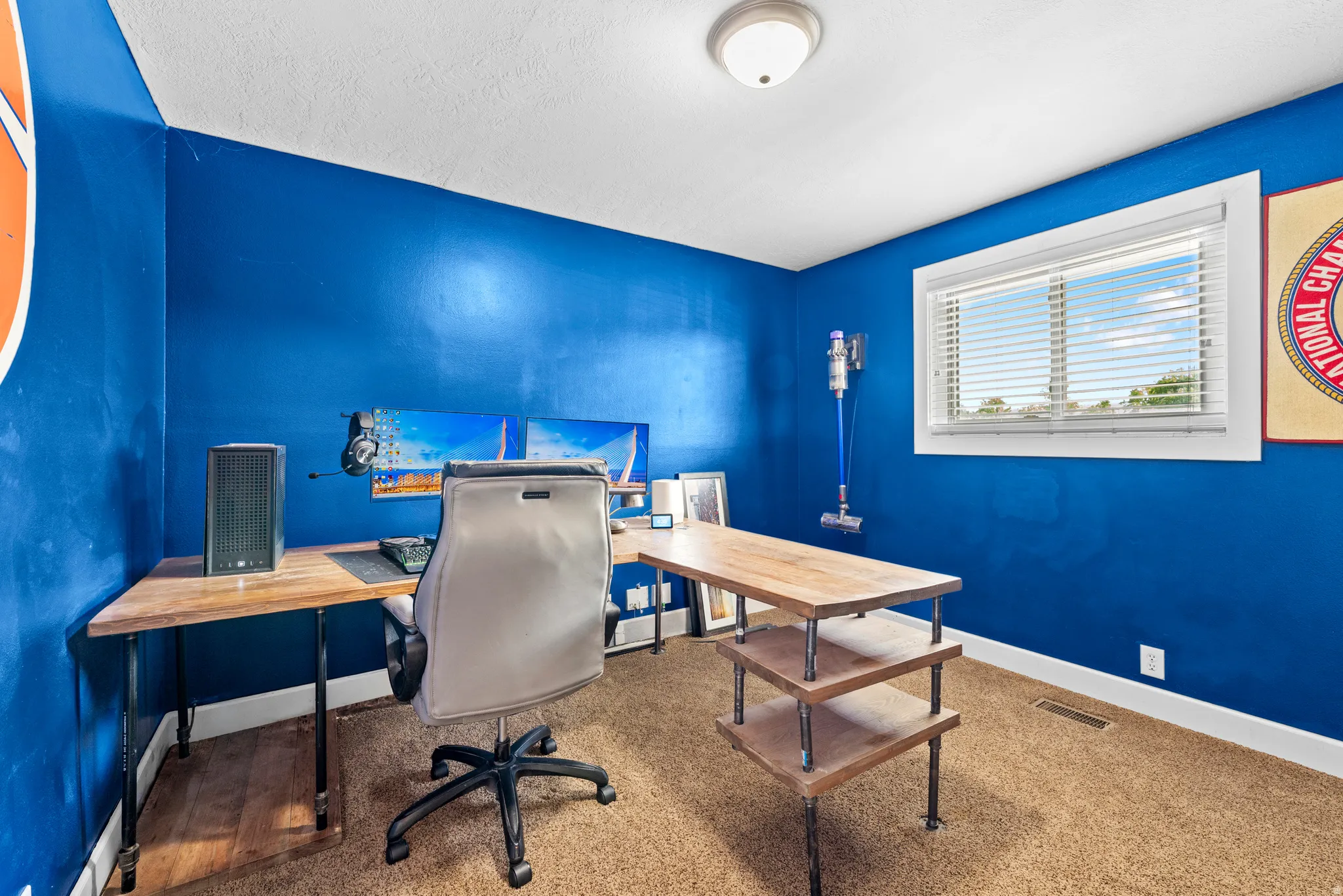 Room featuring a window with blinds, blue walls, and a ceiling-mounted light fixture