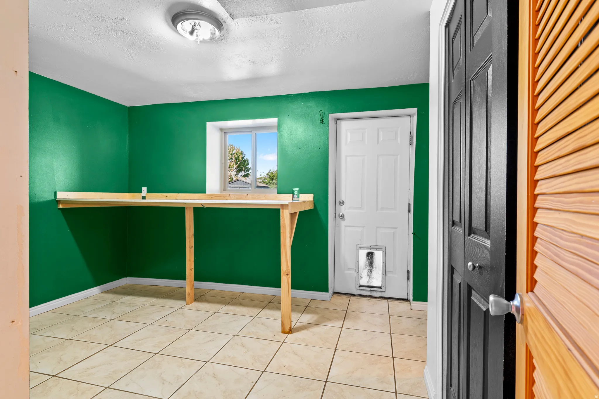 Laundry Room with folding table, and basement exit door.