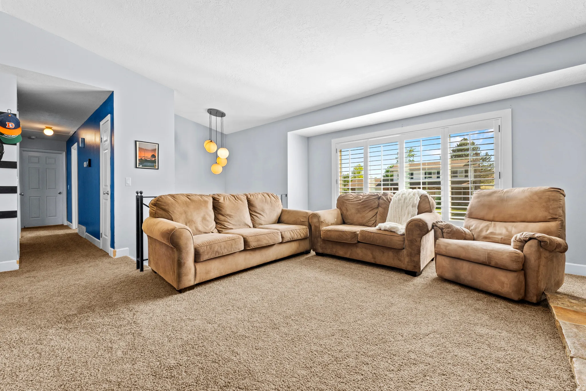 Living area with abundant natural light from a large window featuring white plantation shutters
