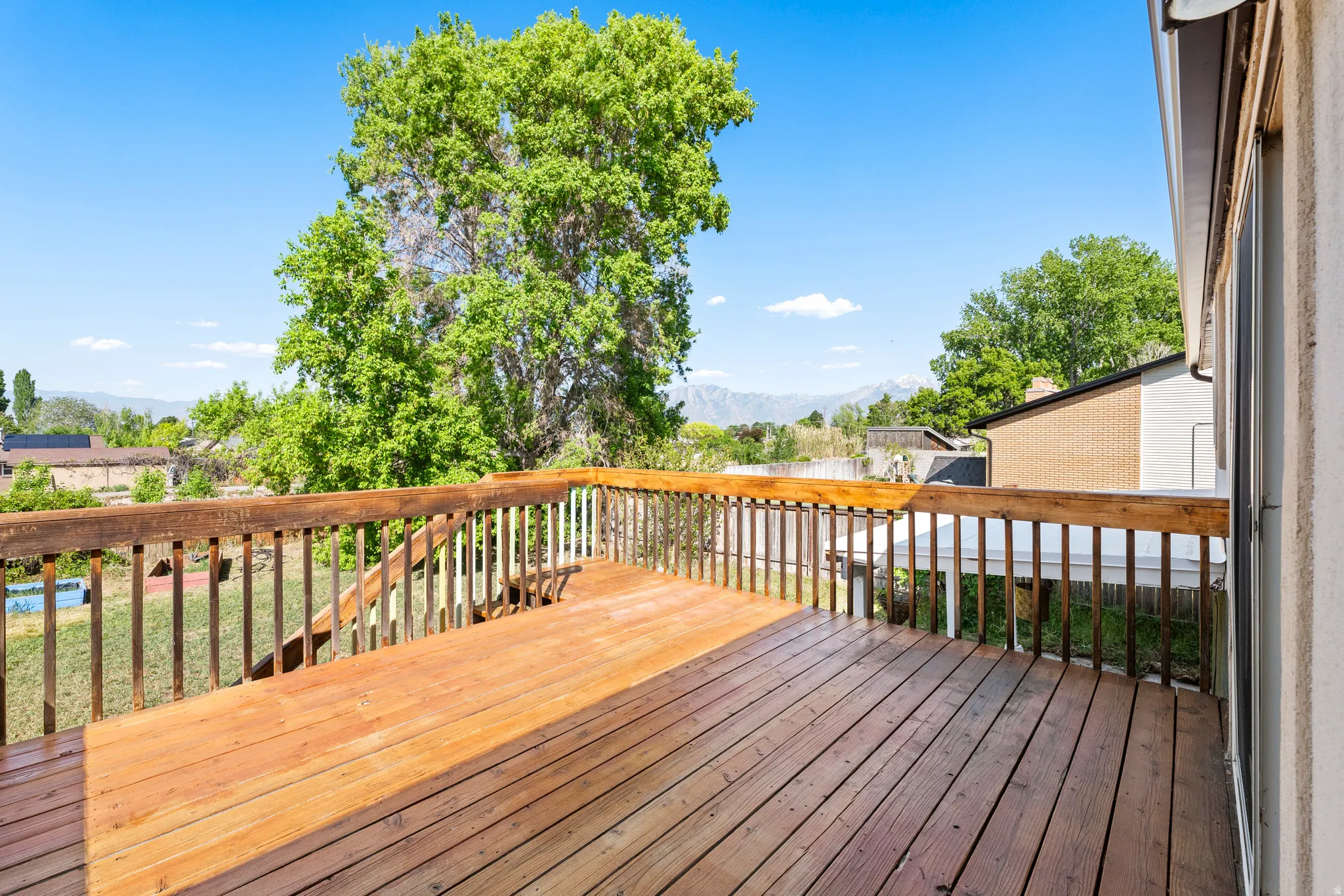 Spacious wooden deck featuring natural wood flooring and coordinating railings