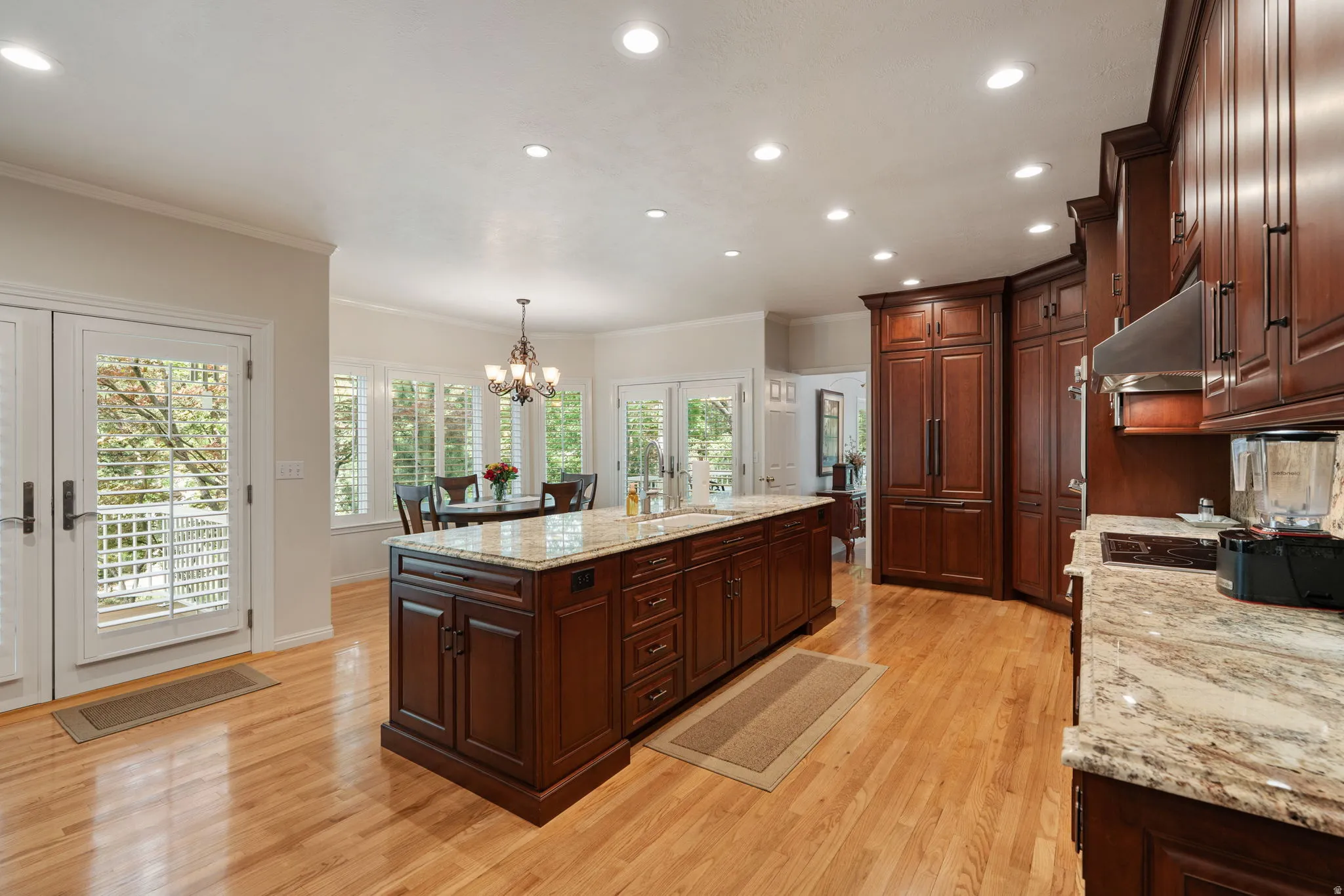 Kitchen featuring wood-finish flooring, mahogany wood cabinetry, integrated refrigerator and dishwasher