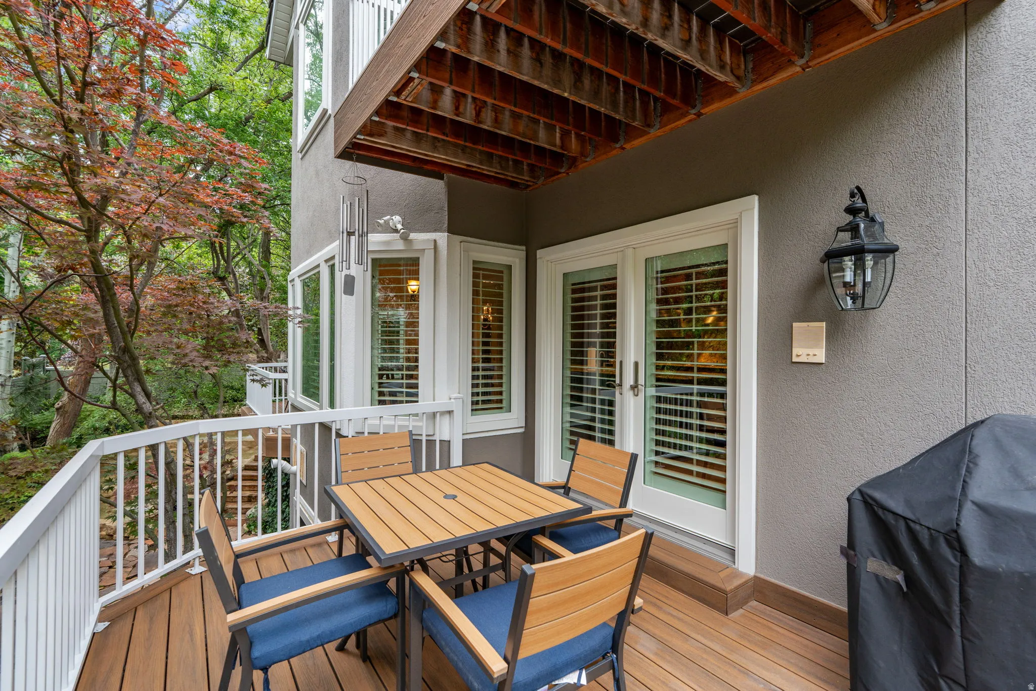 Private outdoor deck accessed from family room with Trex flooring, white railing, and double French doors