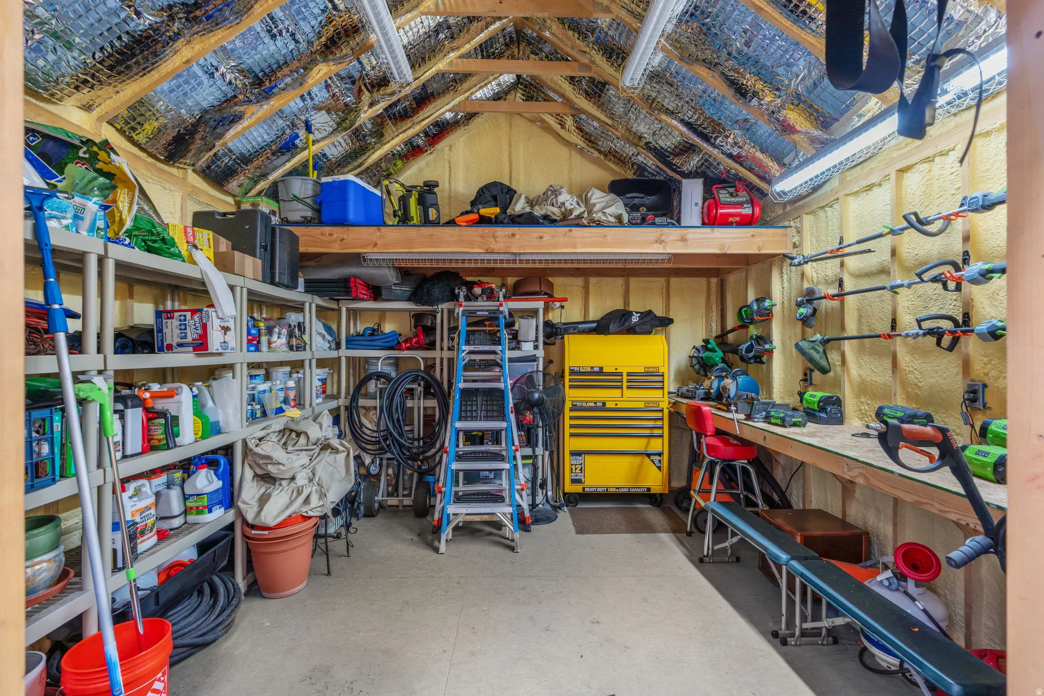 Utility shed interior with workbench, lights, insulated roof, wired with electricity and multiple outlets