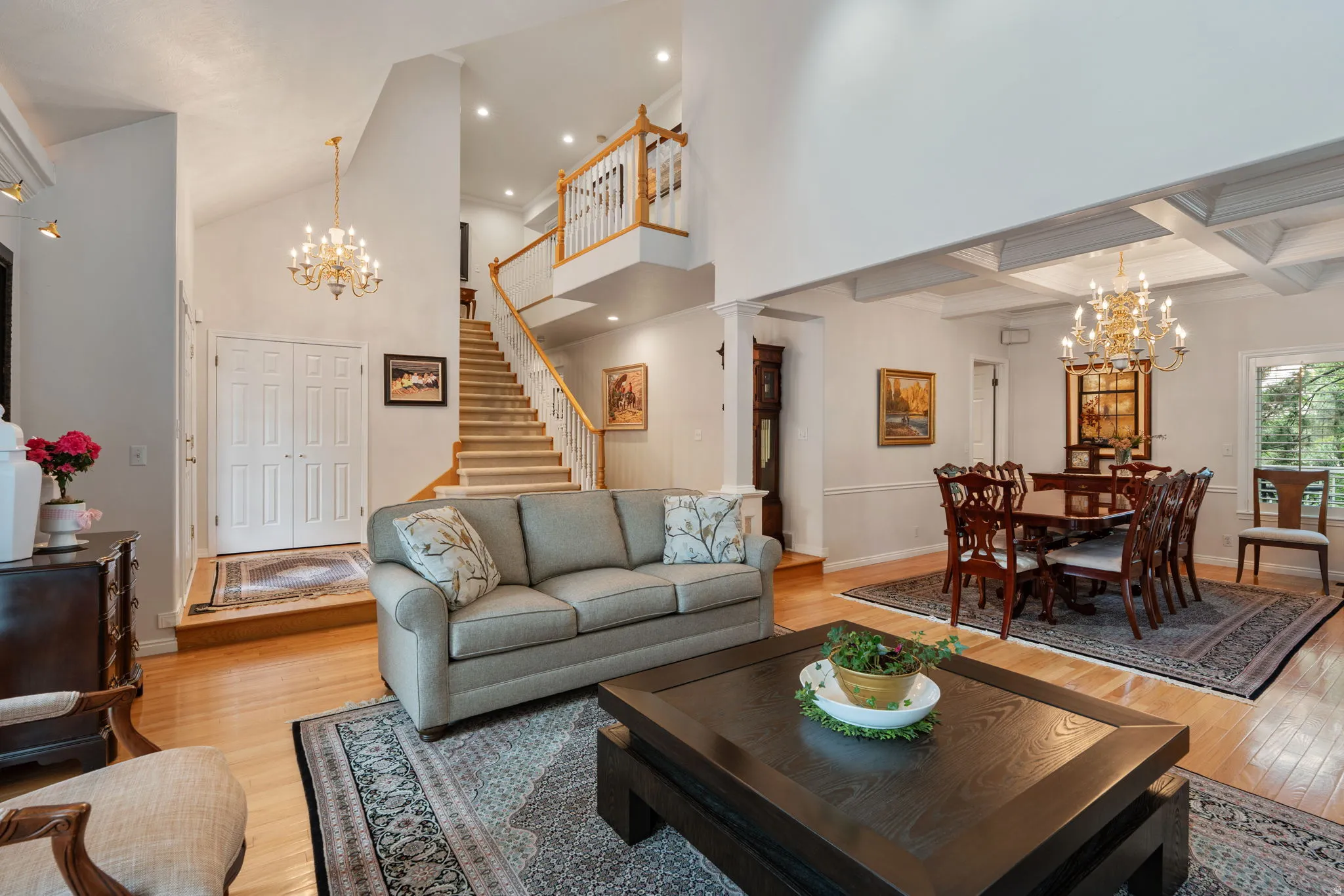 Two-story entryway featuring a grand staircase with wood railings, formal living room and dining room