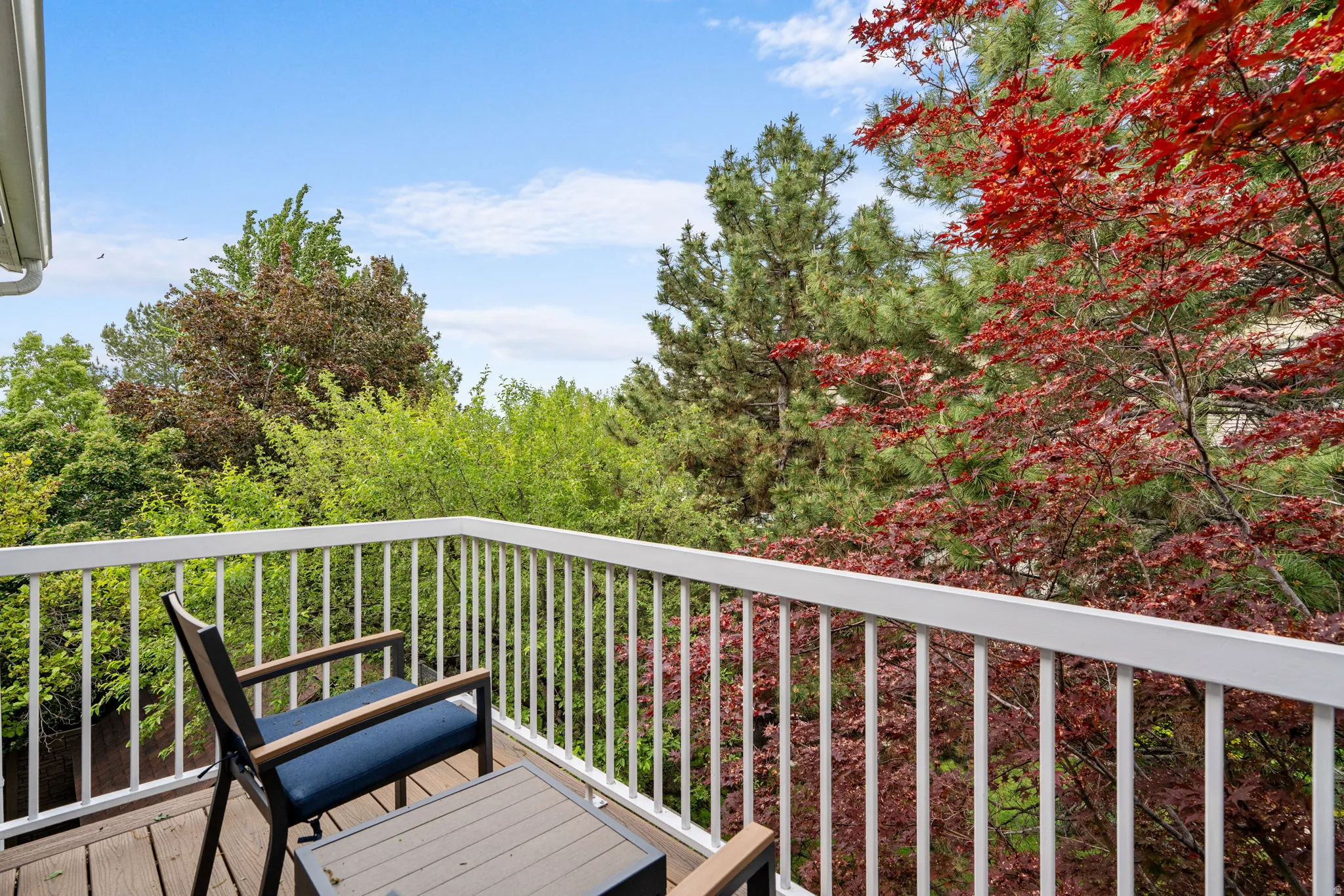 Private balcony off master bedroom featuring Trex flooring and white baluster railing