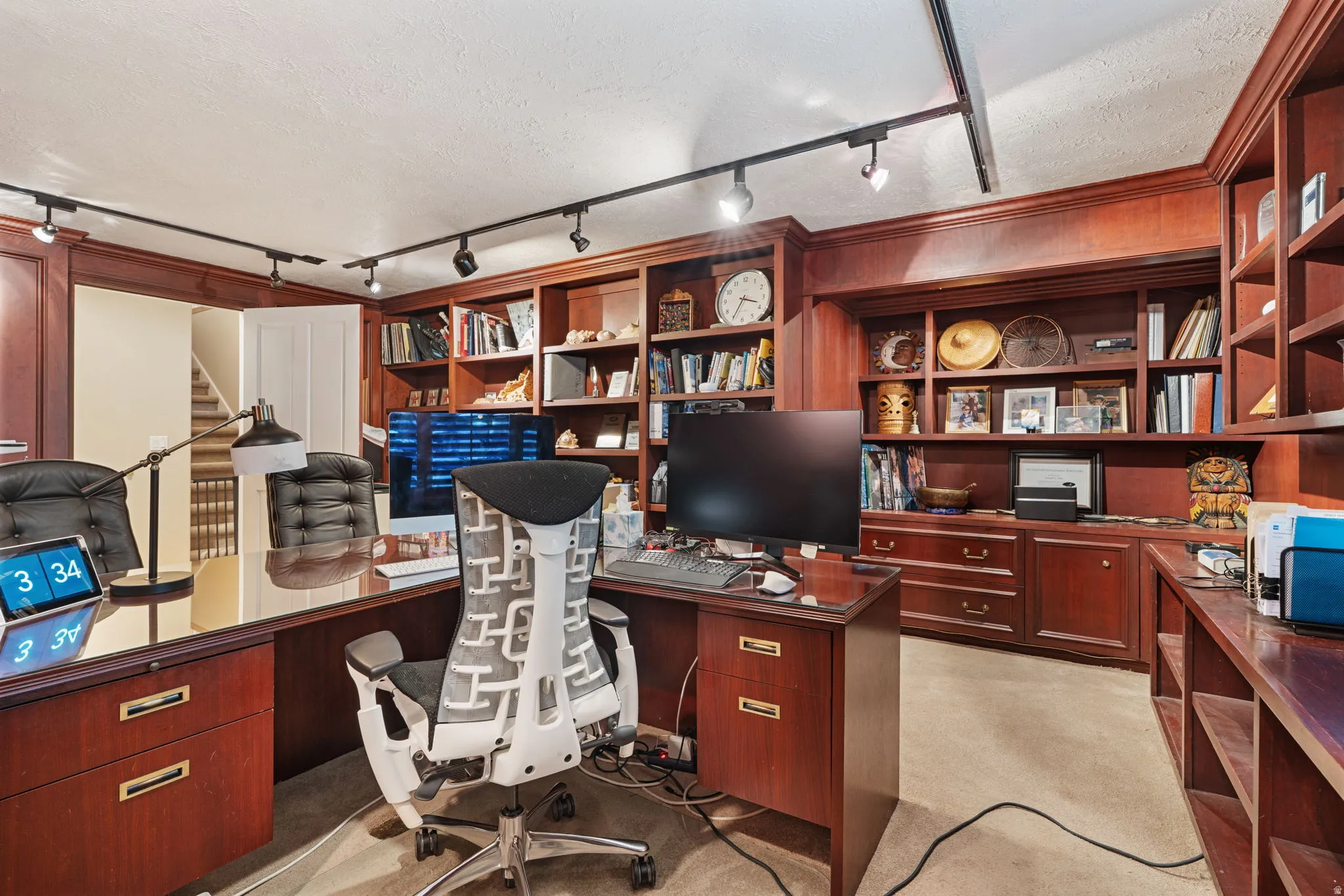 Office space featuring extensive built-in cherry wood cabinetry with integrated shelving and drawers