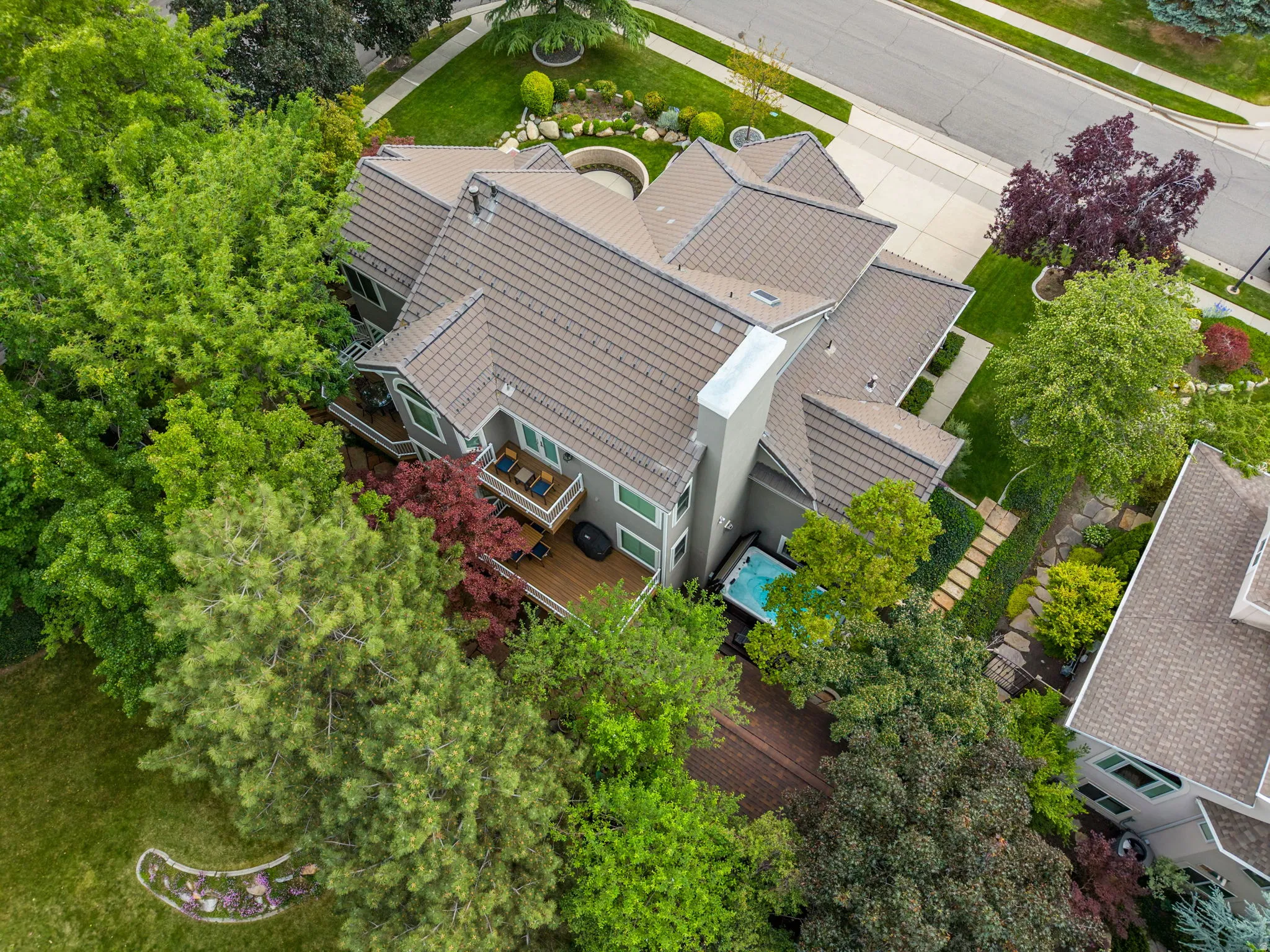 Multi-level property featuring a bartile roof, stucco exterior, and multiple outdoor decks