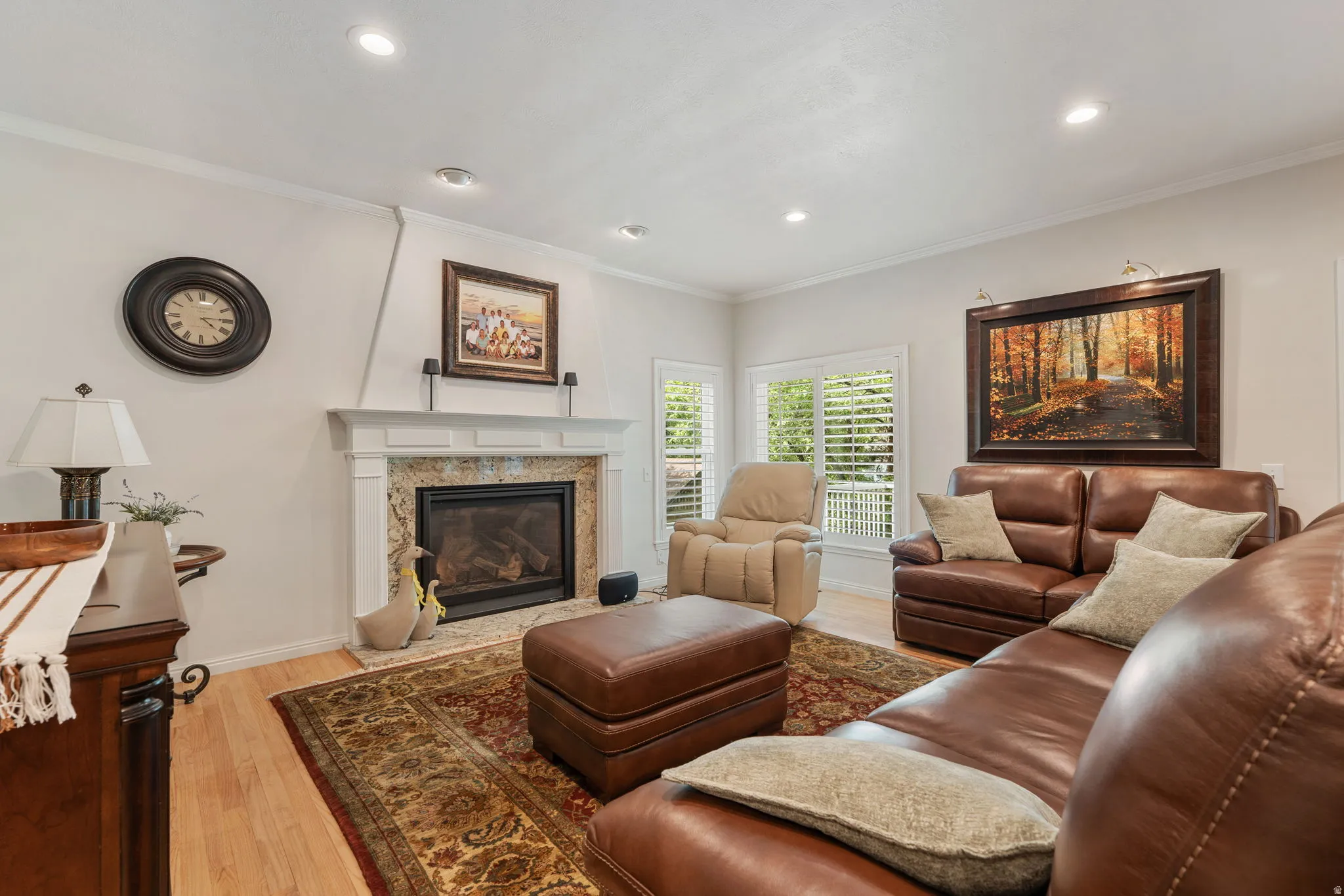 Living area featuring a gas fireplace with  temperature control remote,  hardwood flooring, recessed lighting, and crown molding and surround sound