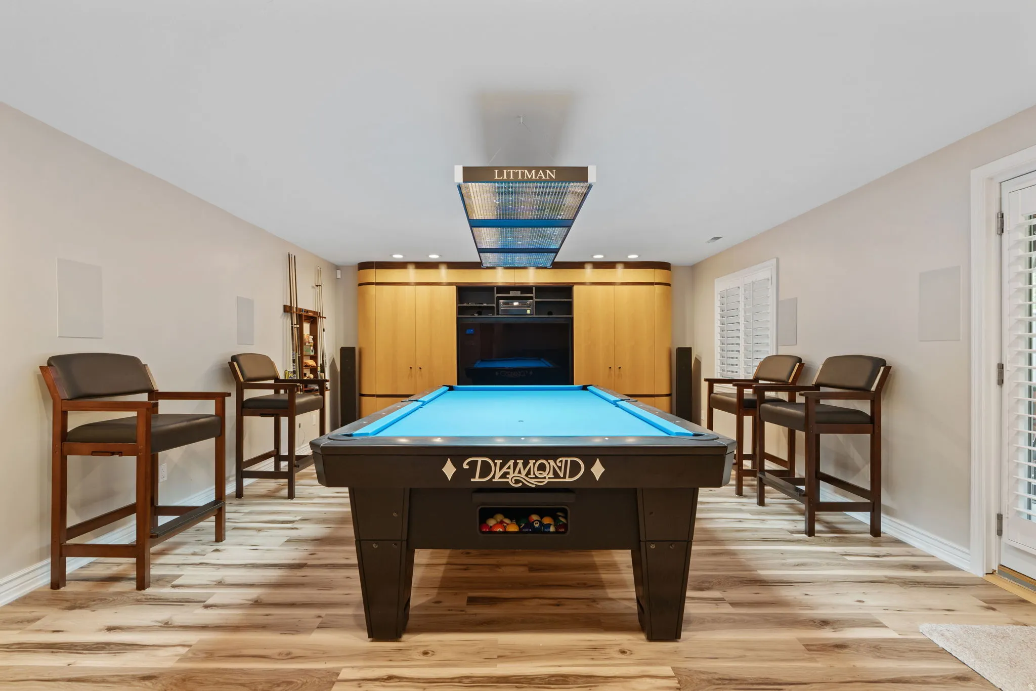 Recreation room featuring Diamond pool table with Littman lamp lighting, wood-finish flooring, and a built-in media center with surround sound