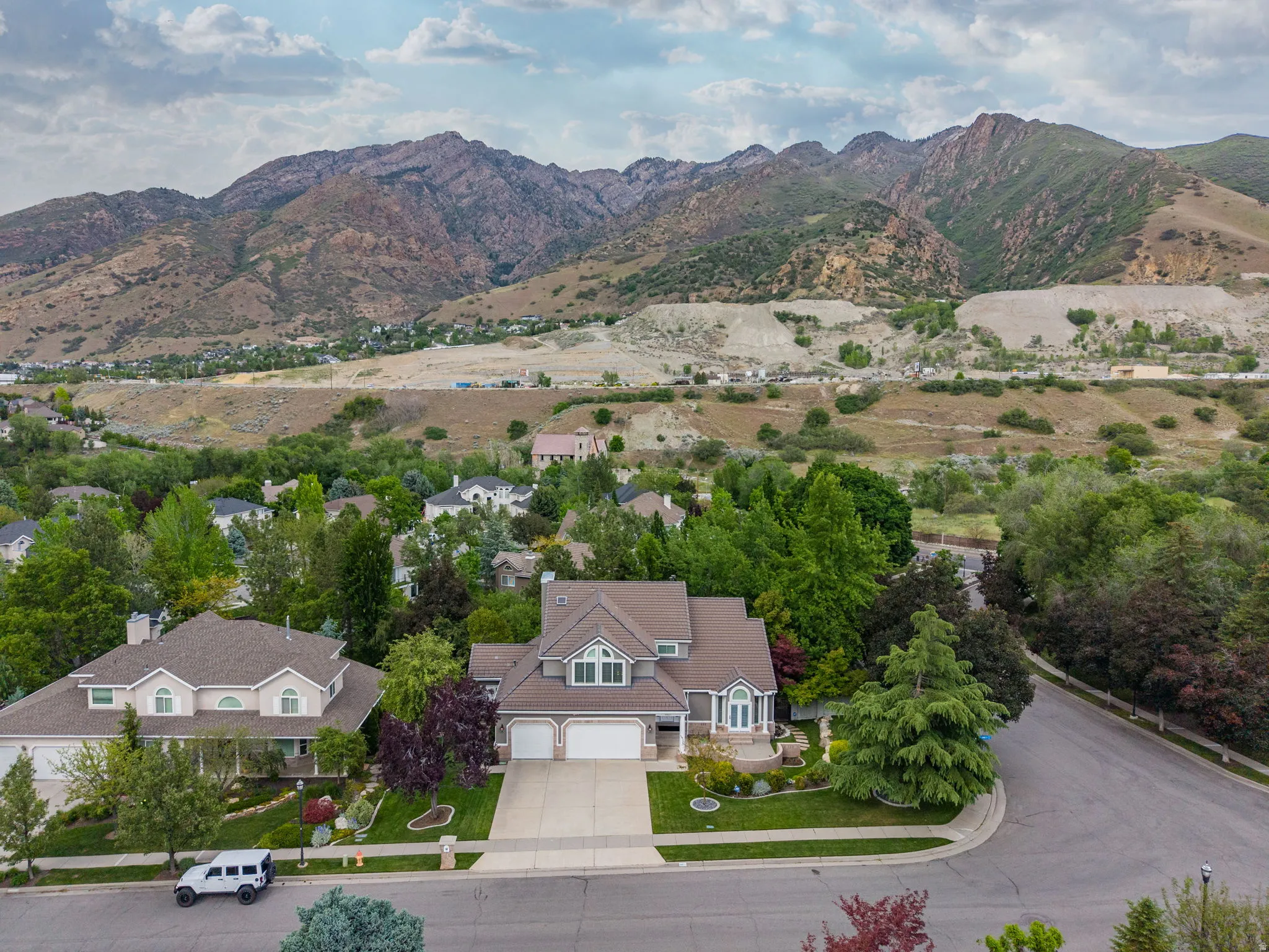 Traditional-style residence featuring a two-car garage, established front landscaping, and a corner lot