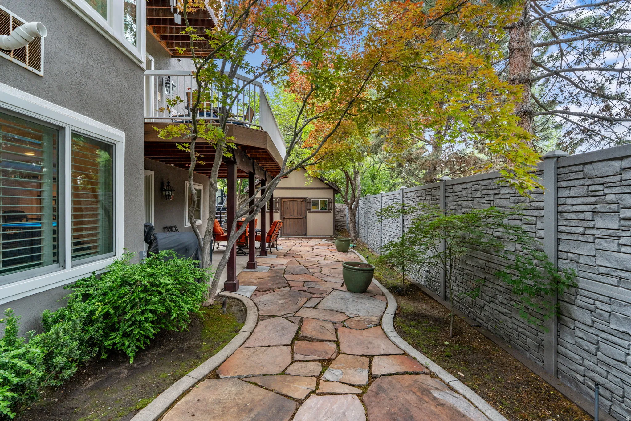 Expansive custom cut stone pathway bordered by mature landscaping