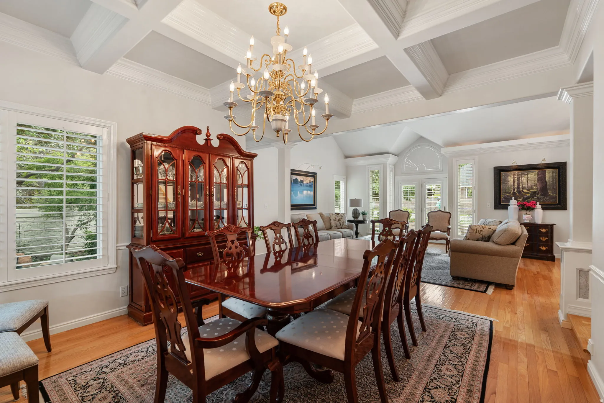 Dining area featuring a coffered ceiling, a brass chandelier, and wood-finish flooring