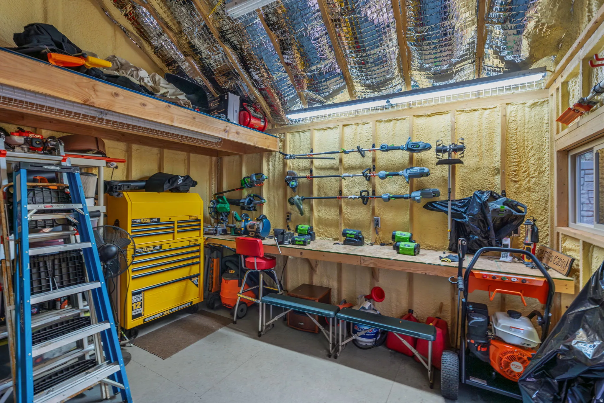 Utility shed interior with workbench, lights, insulated roof, wired with electricity and multiple outlets