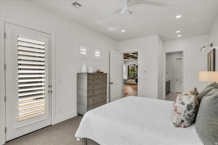 Bedroom featuring a white door with louvered panels, light gray carpeting, recessed ceiling lighting, and a ceiling fan