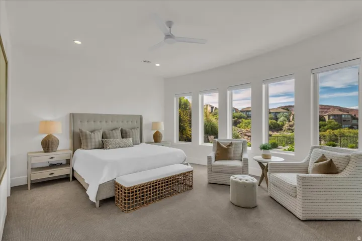 Expansive bedroom featuring a tray ceiling with a ceiling fan, recessed lighting, and a neutral color palette