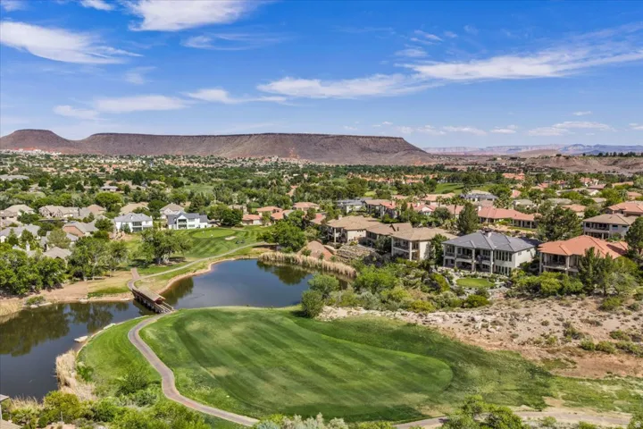Aerial perspective showcasing Sunbrook Communities with a golf course, natural water features, and expansive mountain scenery