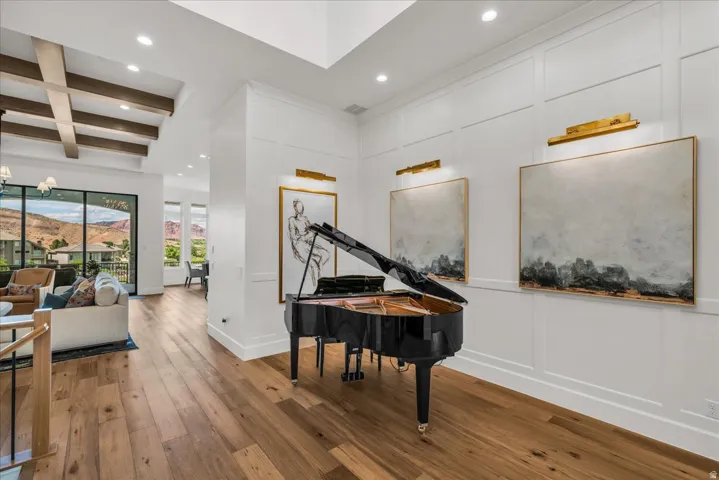 Hardwood flooring throughout featuring recessed lighting and a beamed ceiling