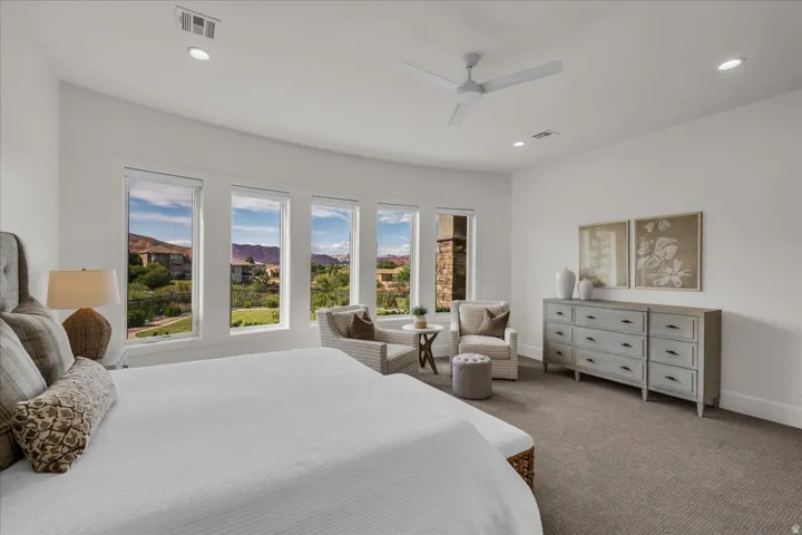 Spacious interior featuring a series of large windows, recessed ceiling lighting, a modern ceiling fan, and light-colored carpeting