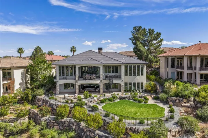 Exterior featuring a multi-level design with a dark shingle roof and a stucco finish