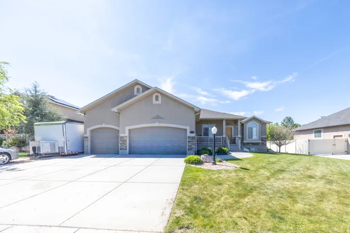 Stucco exterior featuring a large 3 car extra deep garage, covered porch entry, bay window, RV pad and manicured front lawn