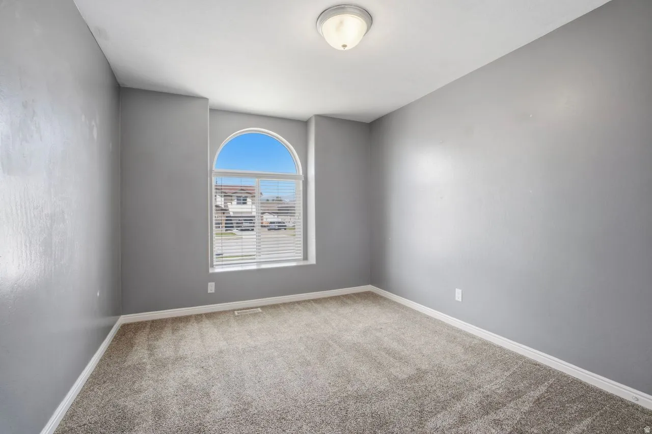 Bedroom featuring light gray walls, plush gray carpet, white baseboards, and a semi-flush mount ceiling light