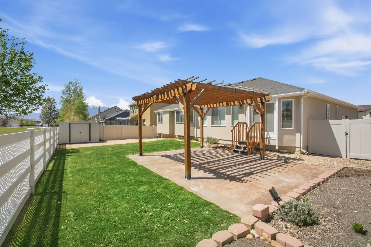 Expansive backyard featuring a wood pergola over a concrete patio