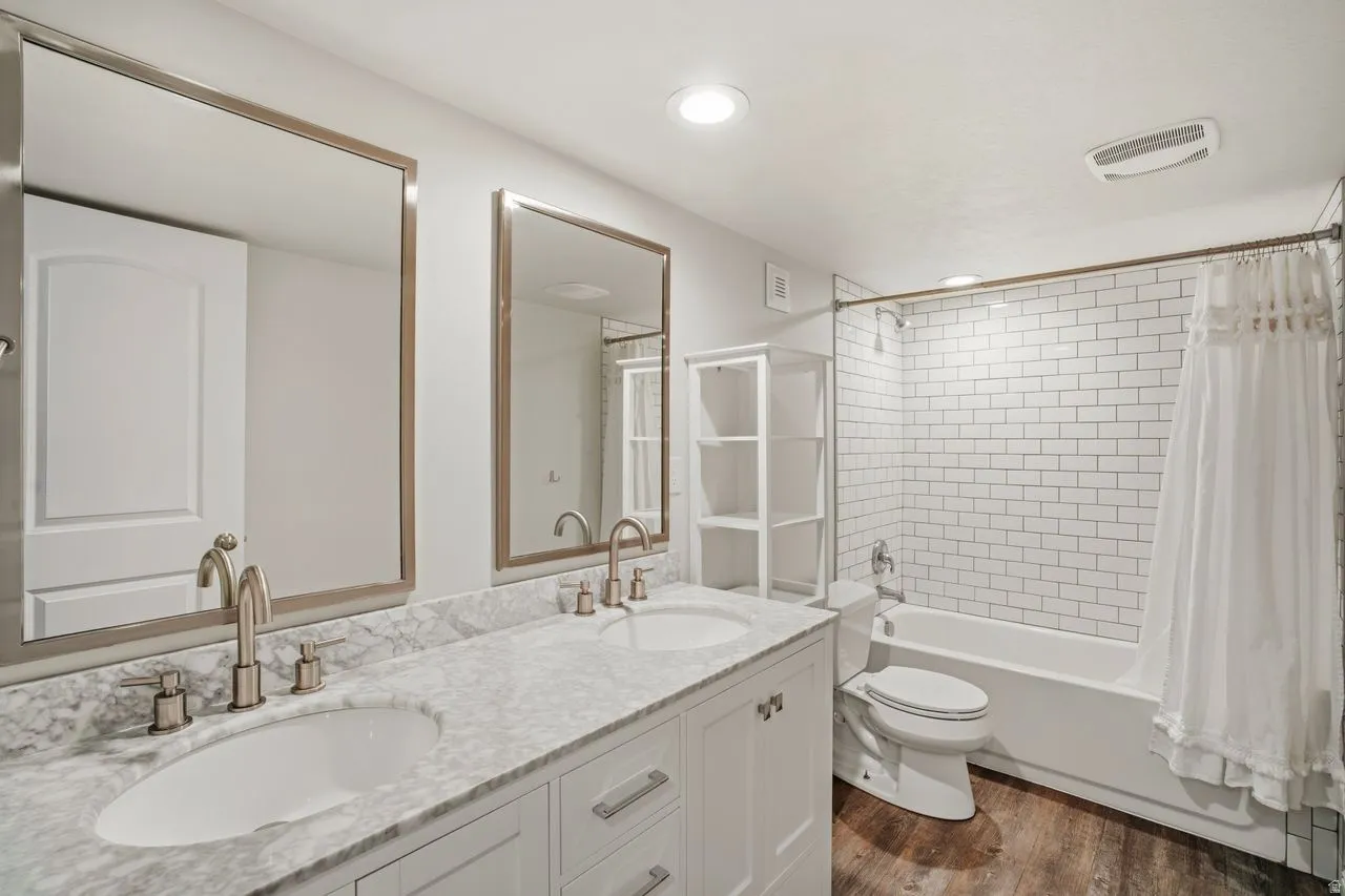 Dual vanity featuring undermount sinks, stone-finish countertop, and brushed nickel fixtures
