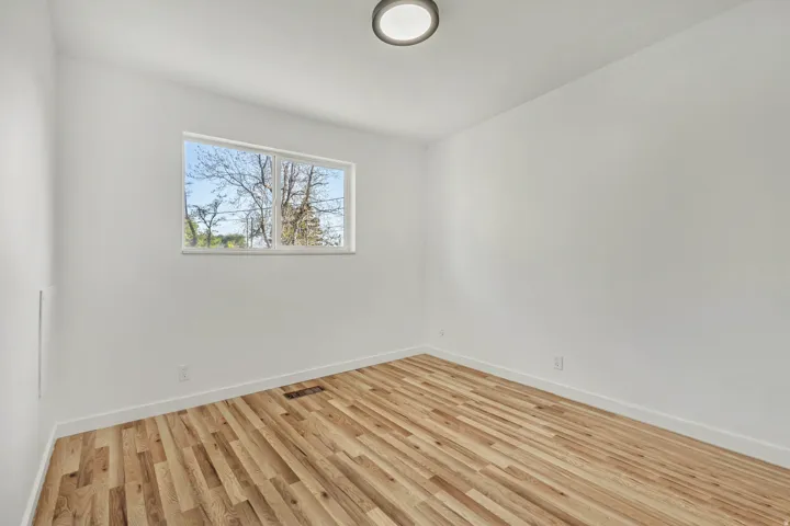 Bright interior space featuring wood-finish flooring, white walls, and a recessed window