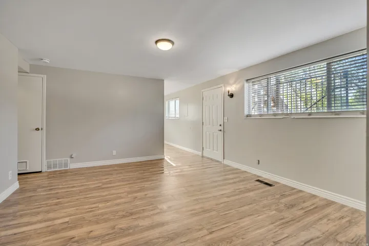 Open-concept living area featuring wood-finish flooring, neutral wall tones, and white trim