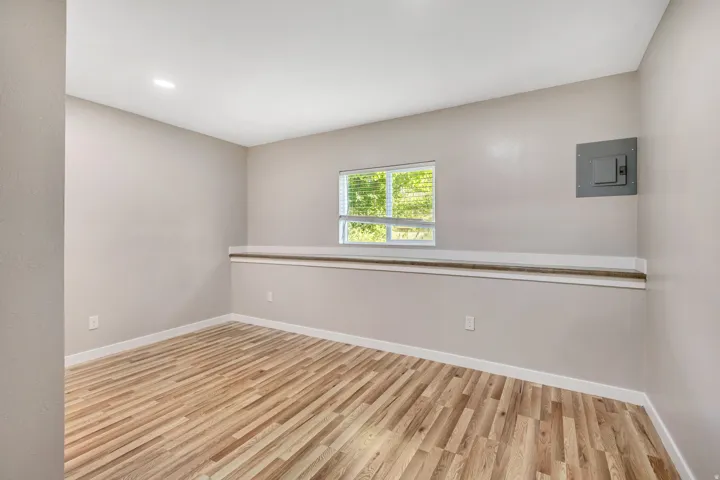 Interior space with wood-finish flooring, a window with blinds, and recessed lighting