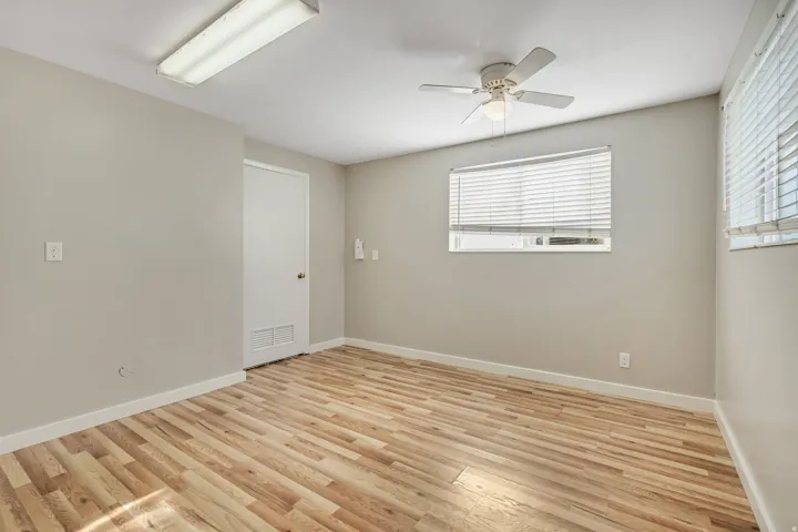 Room featuring wood-finish flooring, neutral wall tones, and white baseboards