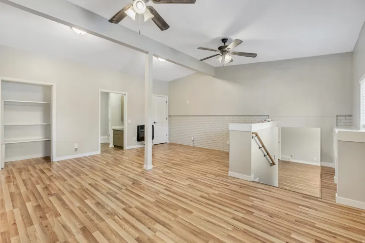 Spacious room featuring wood-finish flooring and light gray painted walls