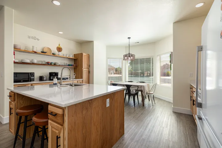 Kitchen featuring a large central island with a light-toned countertop and wood-finish cabinetry