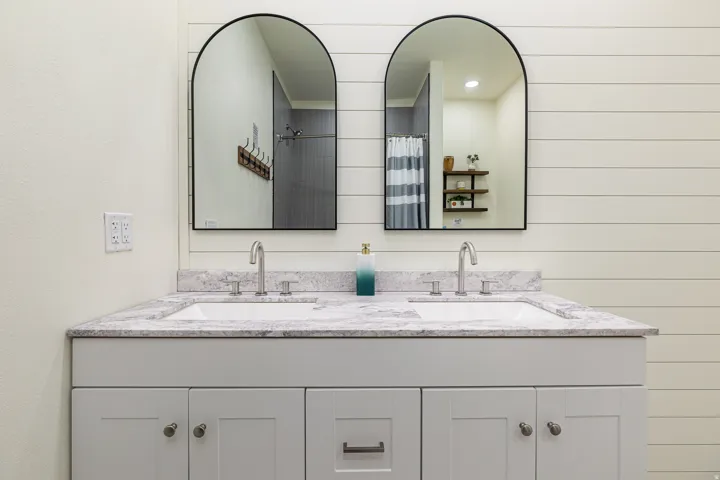 Primary EnSuite Bathroom Double vanity featuring integrated sinks, gray-veined countertop, brushed nickel fixtures, and white shaker-style cabinetry