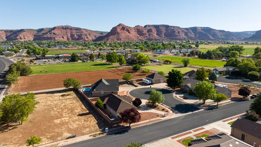 Residential neighborhood featuring single-story homes with dark shingle roofs, paved streets, and mature landscaping