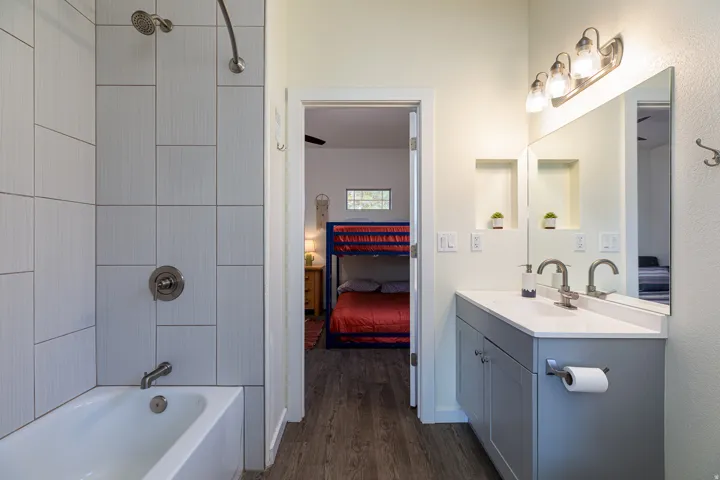 Bathroom featuring a single vanity with a white countertop, large mirror, and brushed nickel fixtures