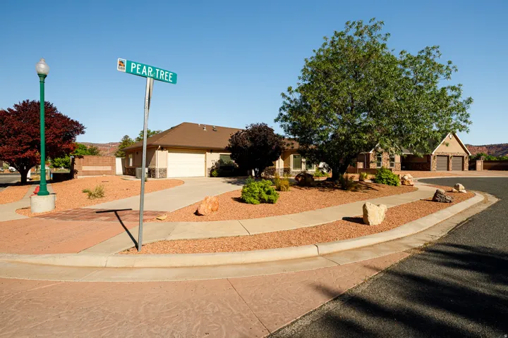 Ranch-style residence featuring a two-car garage, stucco exterior, and a stone accent facade