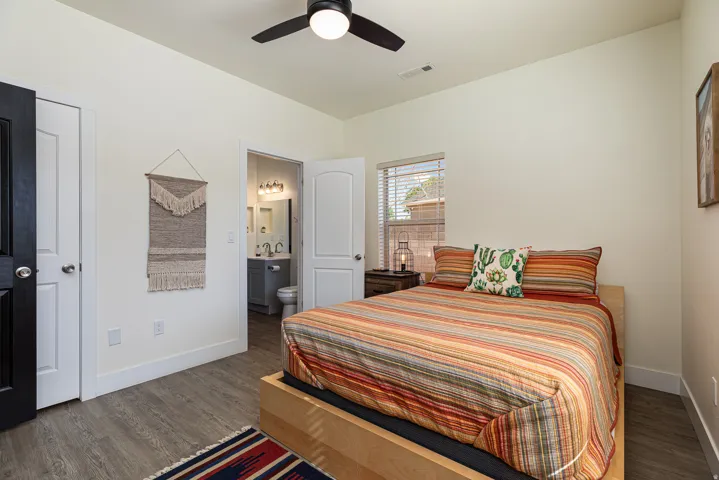Bedroom featuring wood-finish flooring, a ceiling fan, and a window with blinds