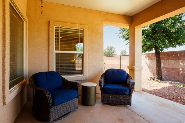 Covered patio with stucco exterior, concrete flooring, and solid privacy fencing