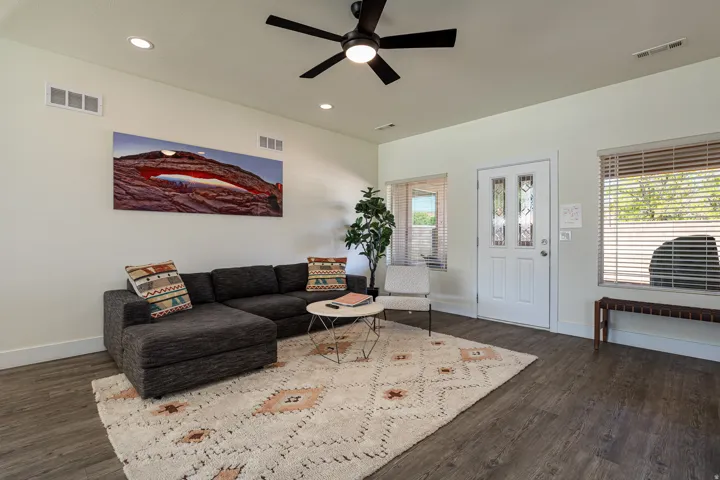 Spacious living area featuring wood-finish flooring, recessed lighting, and a ceiling fan