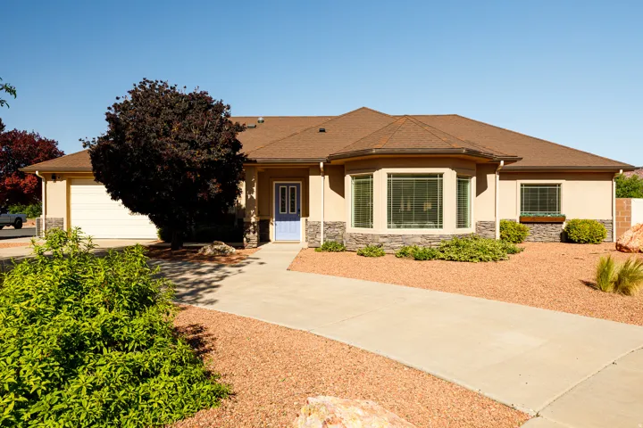 Stucco exterior with a stone veneer accent, featuring a light blue entry door and an attached garage