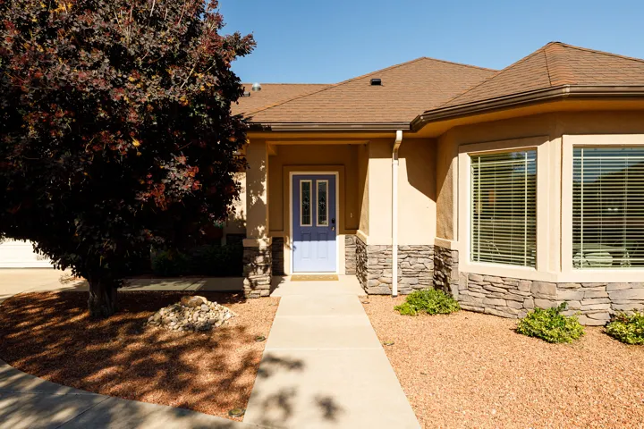 Stucco exterior with a blue entry door and stone accents