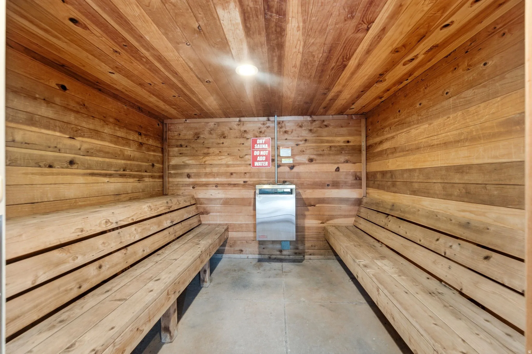 Interior sauna room featuring wood paneling on walls and ceiling
