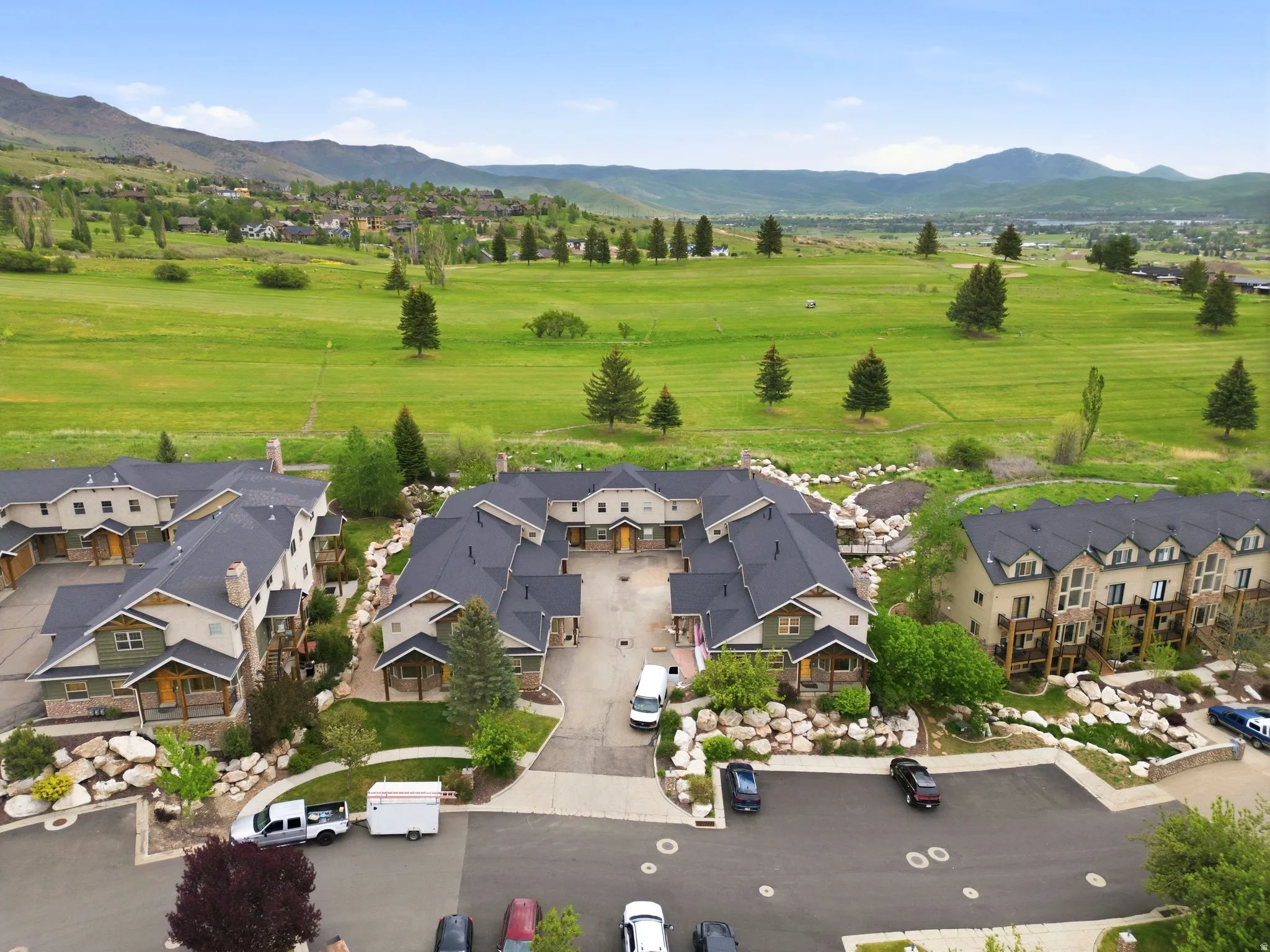 Townhome community featuring varied architectural styles, dark shingle roofs, and stone accents