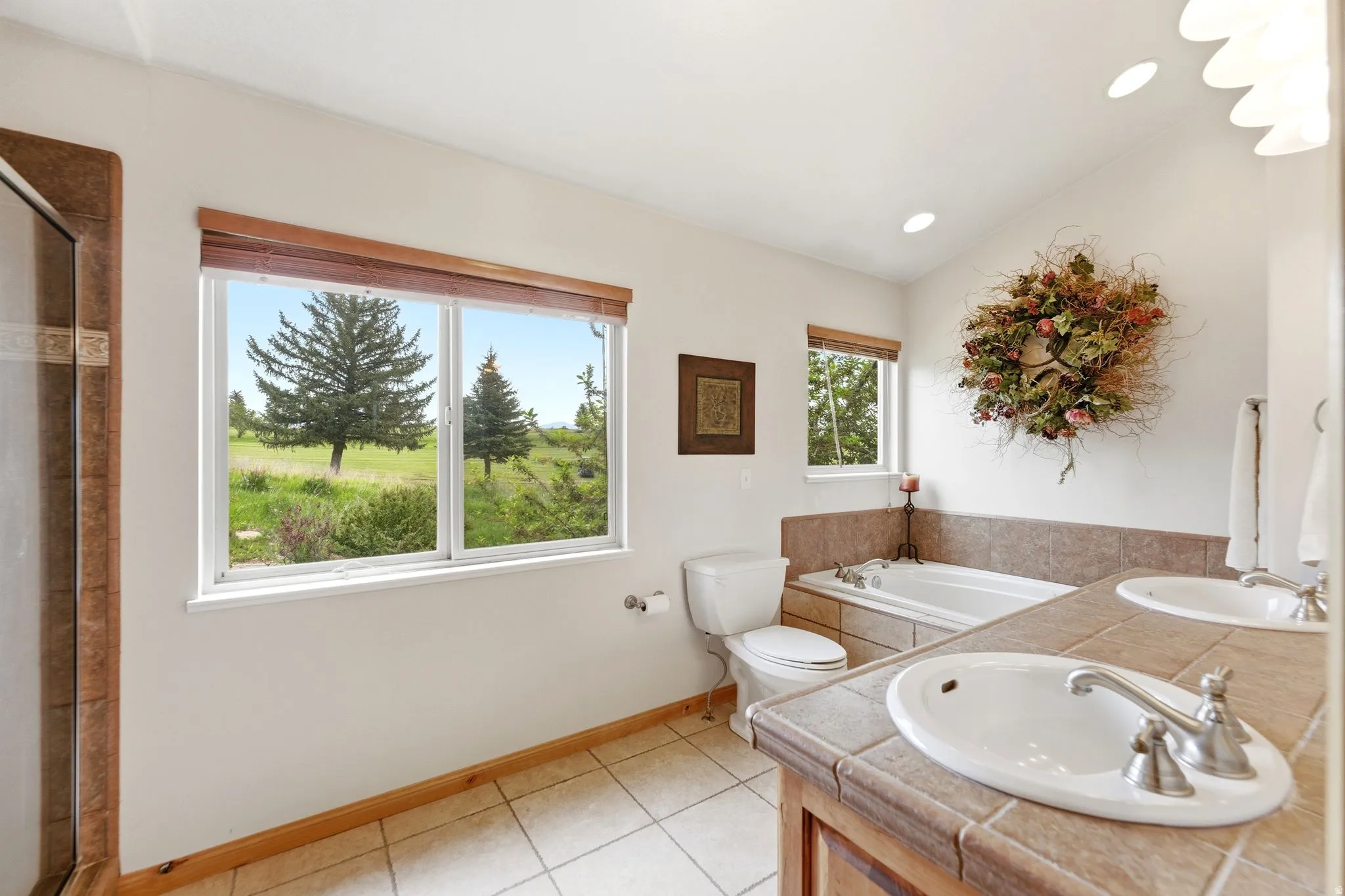 Bathroom with dual windows, a tiled shower enclosure, and a built-in jetted tub