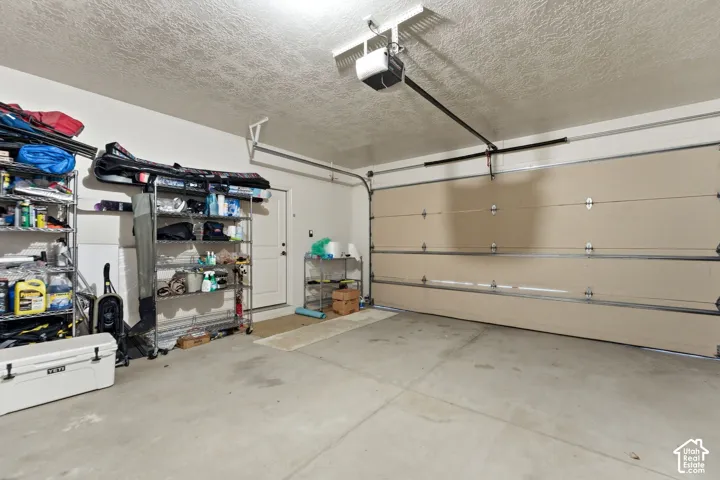 Two-car garage featuring a sectional garage door, concrete flooring, and a ceiling-mounted garage door opener