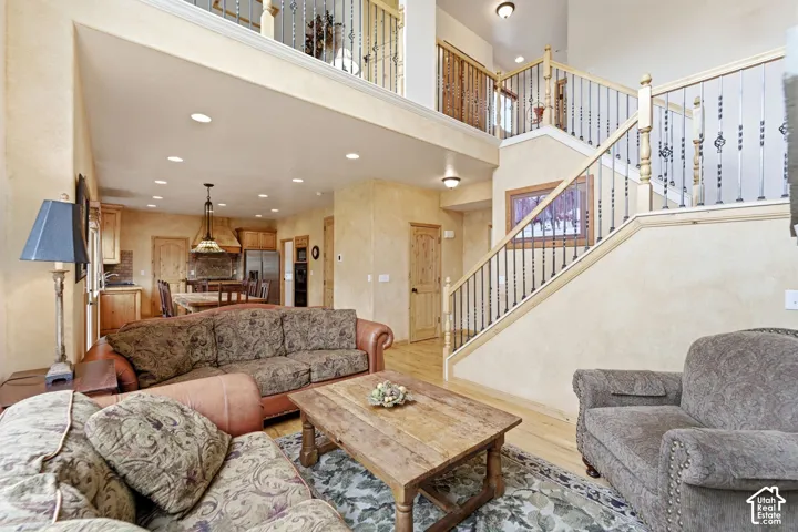 Two-story living area featuring wood-finish flooring and recessed lighting