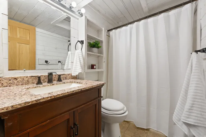 Vanity with granite countertop, integrated sink, and bronze-finish faucet