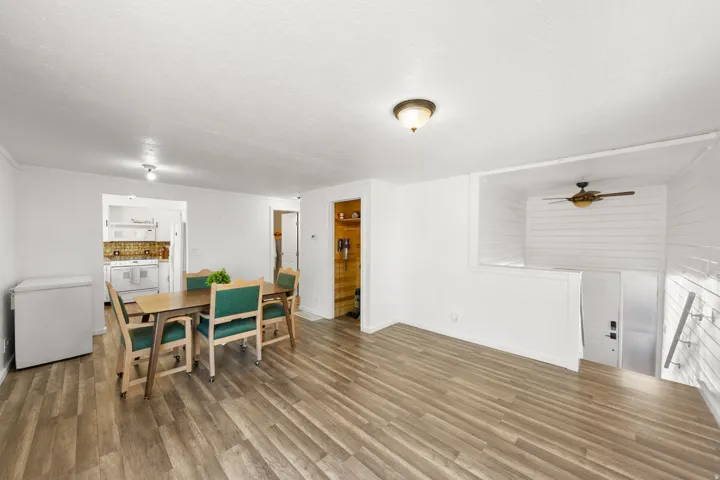 Wood-finish flooring throughout, with a dining area defined by a recessed ceiling light